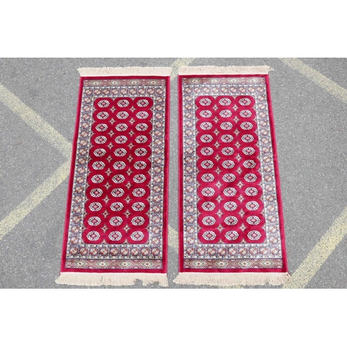 1134 - A pair of red ground Kashmir rugs with traditional Bokhara design, 26½