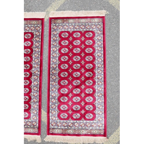 1134 - A pair of red ground Kashmir rugs with traditional Bokhara design, 26½