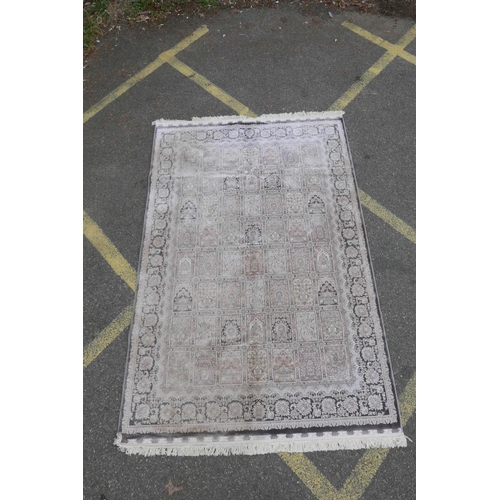 1128 - A pewter ground woven silk rug with a Persian panelled design with birds and flowers, 62