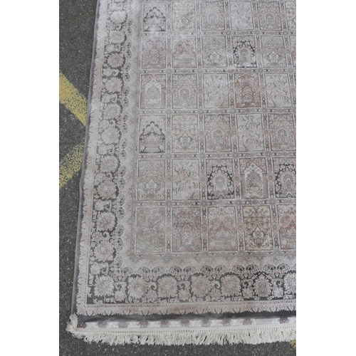 1128 - A pewter ground woven silk rug with a Persian panelled design with birds and flowers, 62