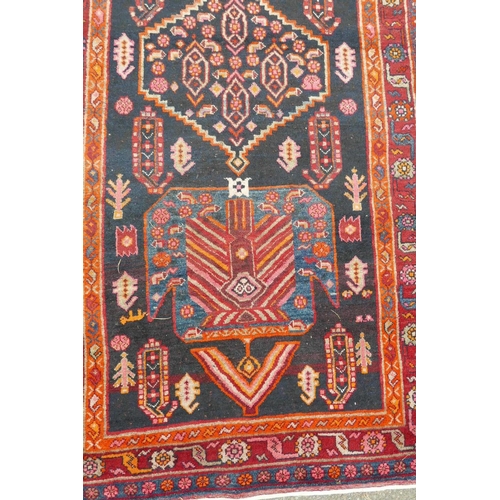 1133 - A red and blue ground Persian wool runner decorated with stylised birds and medallions, 46½