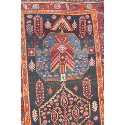 1133 - A red and blue ground Persian wool runner decorated with stylised birds and medallions, 46½