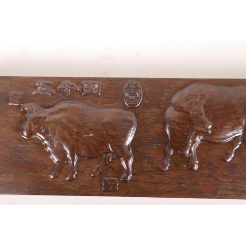 568 - A pair of Chinese hardwood scroll weights embossed with images of cattle and calligraphy, 15