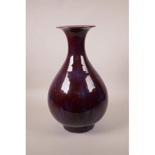 110 - A Chinese flambé glazed pottery pear shaped vase with a flared rim, 13½