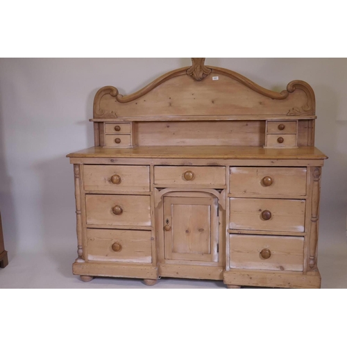 1102 - A C19th pine Lincolnshire dresser with seven drawers flanking a central cupboard, 62