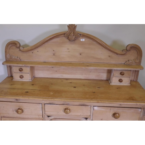 1102 - A C19th pine Lincolnshire dresser with seven drawers flanking a central cupboard, 62