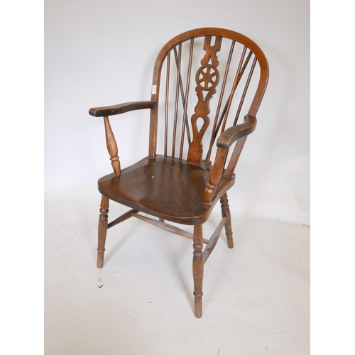 1109 - A C19th elm seated wheelback elbow chair, 39½