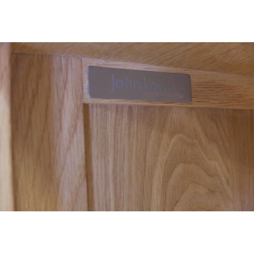 1112 - A John Lewis light oak open bookcase, with adjustable shelves over two glazed cupboards, 40