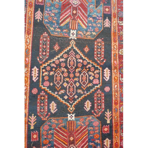 1133 - A red and blue ground Persian wool runner decorated with stylised birds and medallions, 46½