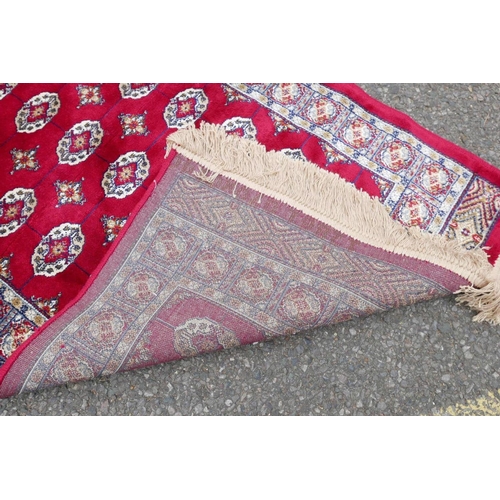 1134 - A pair of red ground Kashmir rugs with traditional Bokhara design, 26½