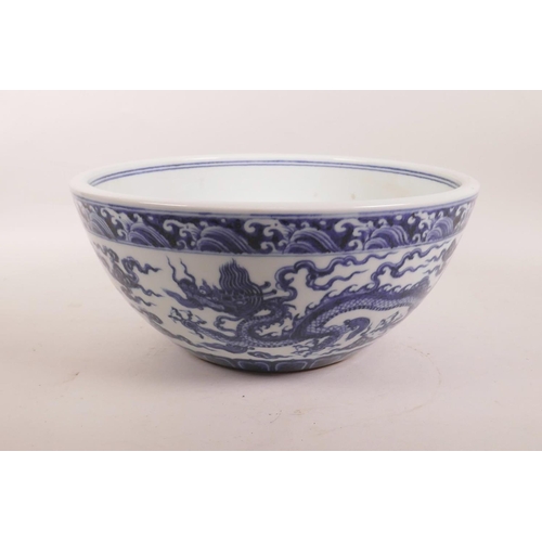 135 - A large Chinese blue and white porcelain bowl decorated with dragons in flight, 6 character mark to ... 