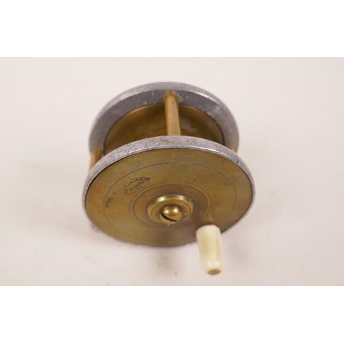 A small vintage brass trout fishing reel stamped A.W. Gamage Ltd