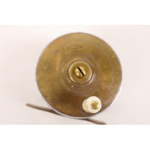 181 - A small vintage brass trout fishing reel stamped A.W. Gamage Ltd, London, 2¼