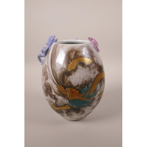 23 - A Chinese polychrome porcelain vase with applied dragon and bat decoration to the lip and red and gi... 