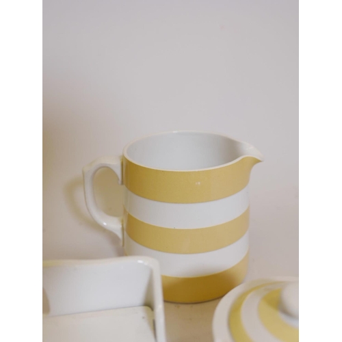 254 - A collection of fourteen pieces of T. and G. Green Cornish kitchen ware in yellow banded glaze, incl... 