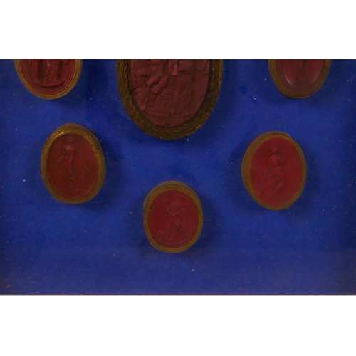 261 - A set of nine Italian C18th Grand Tour red wax intaglios, box mounted on a blue background, 8