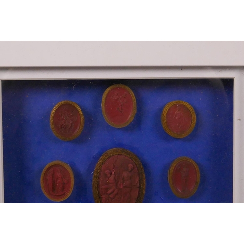 261 - A set of nine Italian C18th Grand Tour red wax intaglios, box mounted on a blue background, 8