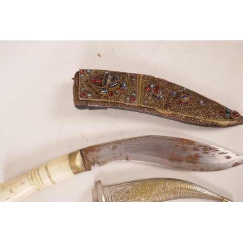 306 - Two Indian daggers, one with bone handle and ornate bejewelled scabbard, the other with engraved whi... 