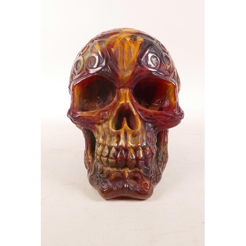 326 - An amber style resin skull with esoteric decoration, 5