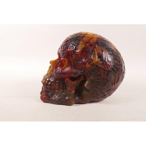 326 - An amber style resin skull with esoteric decoration, 5