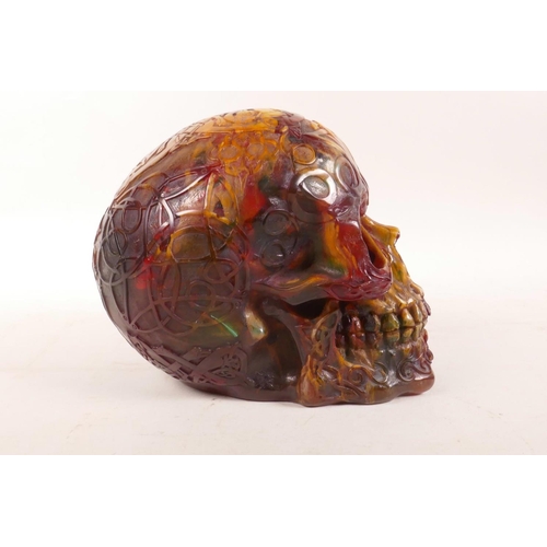 326 - An amber style resin skull with esoteric decoration, 5