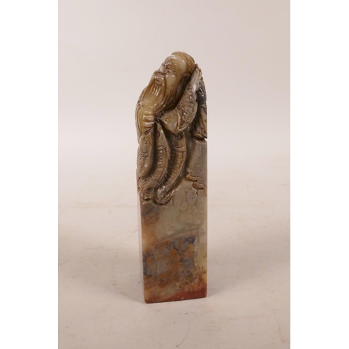 335 - A Chinese soapstone seal with carved decoration of a fisherman to top, 4½