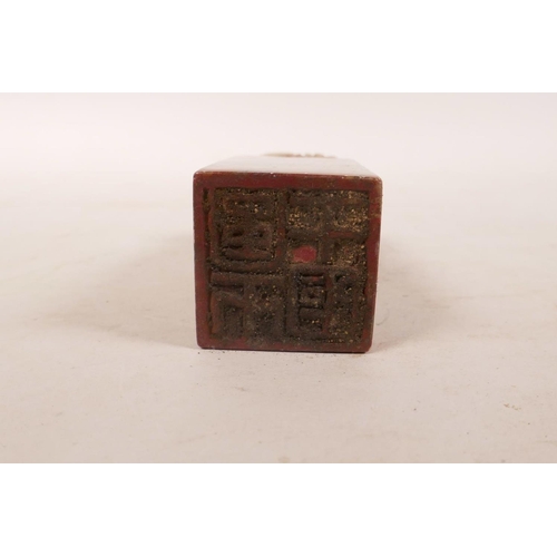 335 - A Chinese soapstone seal with carved decoration of a fisherman to top, 4½