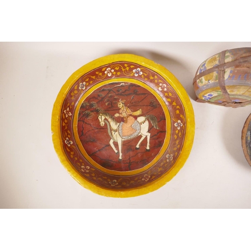 367 - An Indian hand painted wooden charger decorated with a figure on horseback, a smaller Indian bowl wi... 