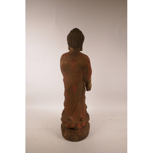 378 - A Chinese carved and painted wood figure of Buddha standing on a lotus flower, A/F minor losses, 22½... 