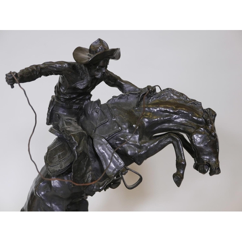 389 - After Frederic Remington, 'Bronco Buster', patinated bronze figure of a cowboy, impressed with signa... 