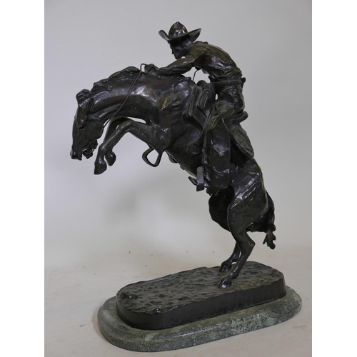 389 - After Frederic Remington, 'Bronco Buster', patinated bronze figure of a cowboy, impressed with signa... 