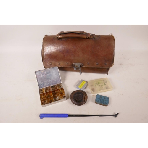 39 - A leather bag containing various vintage fishing equipment including fly box and flies, 11