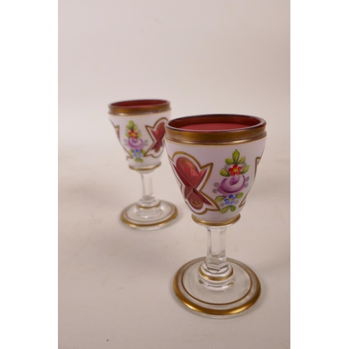 392 - A Bohemian white cased red glass liquer set of decanter and four glasses, painted with flowers in br... 