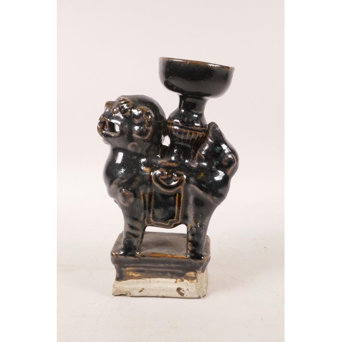 393 - A Chinese black glazed pottery candlestick in the form of a fo dog, 7