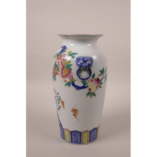 43 - A Chinese polychrome porcelain vase with twin mask handles and fruiting pomegranate tree decoration,... 