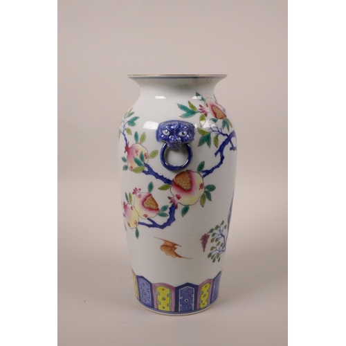 43 - A Chinese polychrome porcelain vase with twin mask handles and fruiting pomegranate tree decoration,... 