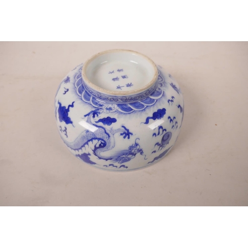 485 - A Chinese blue and white porcelain bowl decorated with dragons chasing the flaming pearl, 6 characte... 