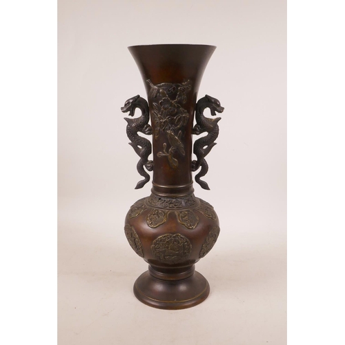 502 - A Japanese bronze vase with two dragon handles and raised decoration of birds amongst flowers, lacks... 