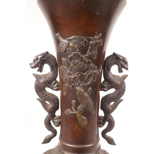 502 - A Japanese bronze vase with two dragon handles and raised decoration of birds amongst flowers, lacks... 