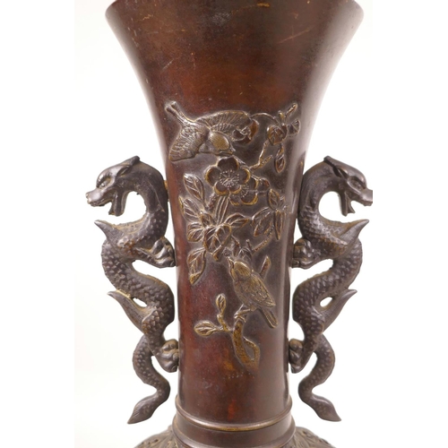 502 - A Japanese bronze vase with two dragon handles and raised decoration of birds amongst flowers, lacks... 