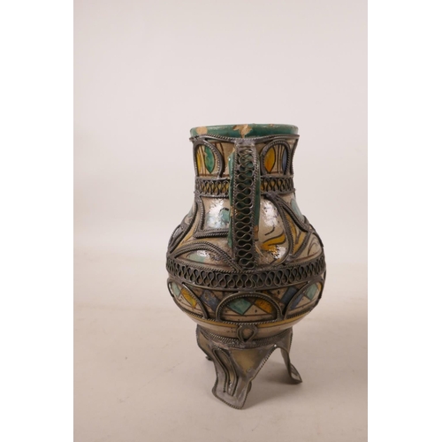 517 - A North African pottery ewer with metal mounts, A/F repair to rim, 7½