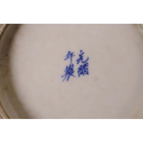 521 - An early C20th Japanese blue and white saucer with polychrome enamel decoration of two women in an o... 