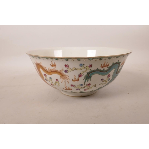 523 - A Chinese polychrome enamelled porcelain bowl decorated with two dragons chasing the flaming pearl, ... 