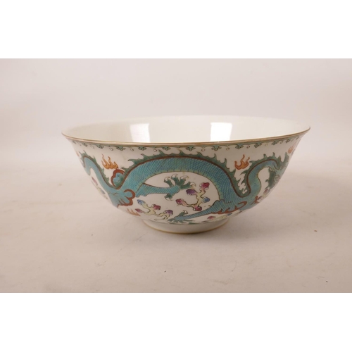 523 - A Chinese polychrome enamelled porcelain bowl decorated with two dragons chasing the flaming pearl, ... 