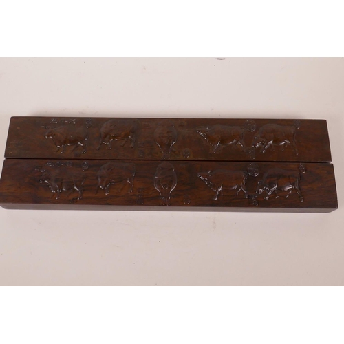 568 - A pair of Chinese hardwood scroll weights embossed with images of cattle and calligraphy, 15