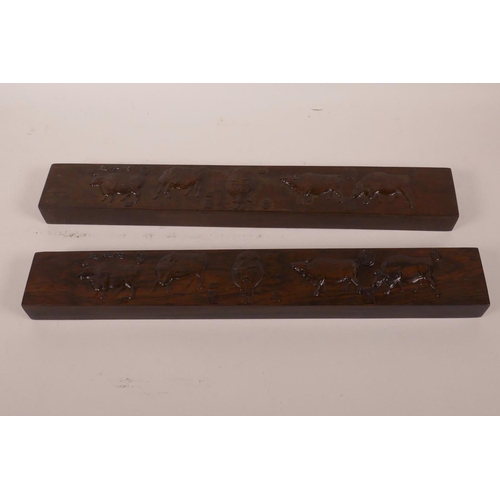 568 - A pair of Chinese hardwood scroll weights embossed with images of cattle and calligraphy, 15