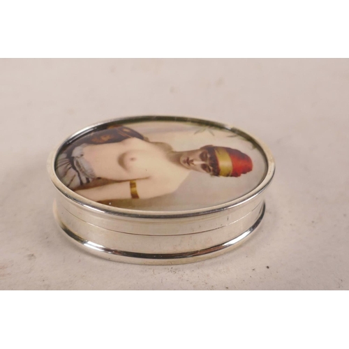 619 - A sterling silver pill box decorated with a cold enamel plaque depicting a semi-clad woman, 1