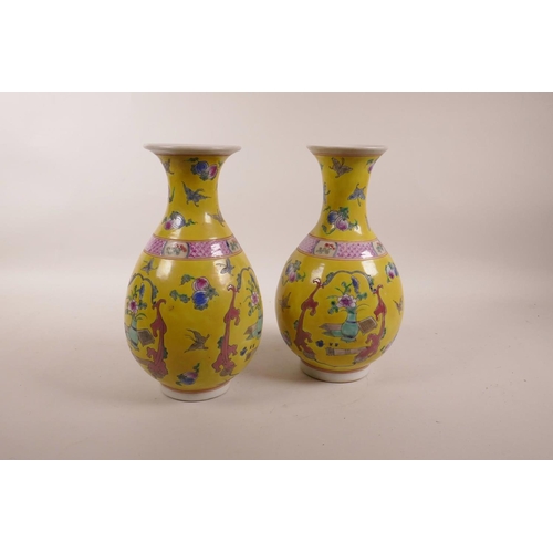 83 - A pair of Chinese yellow ground porcelain pear shaped vases decorated in polychrome enamels depictin... 