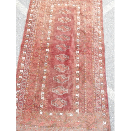 1138 - A Bokhara carpet with geometric designs on a brick red field, 83