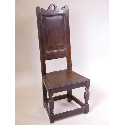 1136 - A C17th/C18th oak high back Wainscot chair with fielded panel back, 44½